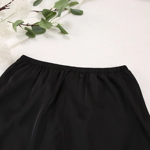 Détail de la taille élastique d'un pyjama en soie noire avec tissu lisse et coutures fines