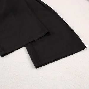 Gros plan du pantalon de pyjama noir montrant la texture du tissu et l'ourlet précis