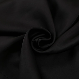Macro d'un tissu en satin noir de qualité avec un éclat soyeux et un drapé fluide