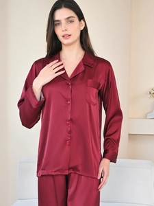 Close-up of burgundy silk satin pajamas featuring notched lapel and chest pocket detail