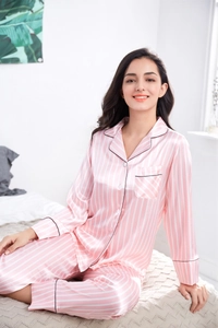 Close-up of pink striped faux silk pajamas with notched collar and black piping detail