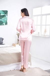 Detail of pink and white striped satin pajamas featuring contrast piping on back and cuffs