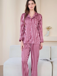 Detail view of striped silk pajama set featuring button-up shirt and matching trousers