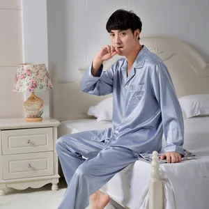 Detail of greyish-blue satin men's pajamas set with white piping and chest pocket embroidery