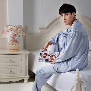 Macro detail of men's satin silk pajamas with white piping and chest pocket embroidery