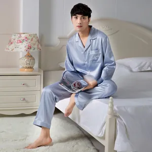 Detail of light blue satin pajamas featuring a notched lapel and white pocket embroidery