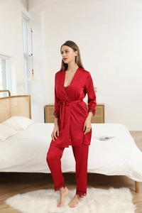 Detail of red silk robe sleeve and pants featuring intricate black lace trim and satin finish