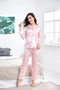 Detail of pink and white vertical stripe satin pajama set with black piping and notched lapel