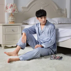 Detail of light blue silk-like pajama set with white piping and lapel collar for men