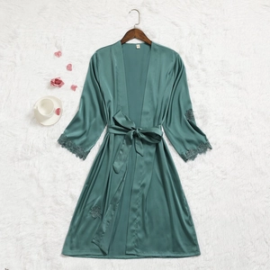 Détail du peignoir en soie vert foncé avec bordure en dentelle et ceinture à nouer