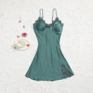Détail de la chemise de nuit en satin vert foncé avec dentelle sur fond en peluche blanc
