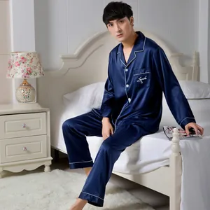 Close-up of men's navy blue satin pajamas set with white contrast piping and embroidery