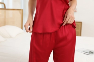 Close-up of red ice silk pajama set with lace trim and glossy satin fabric texture