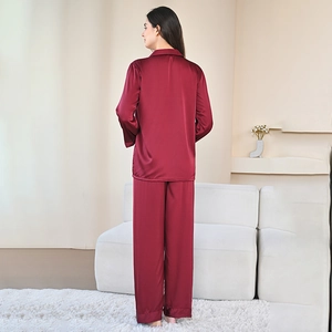 Burgundy silk satin pajamas set with long sleeves and pants in a cozy home setting
