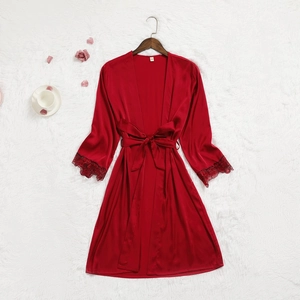Détail d'un peignoir en satin bordeaux avec dentelle noire et ceinture assortie