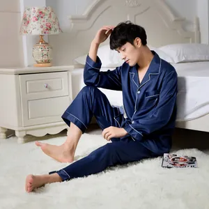 Detail of navy blue satin pajama set with contrast piping and embroidery on breast pocket
