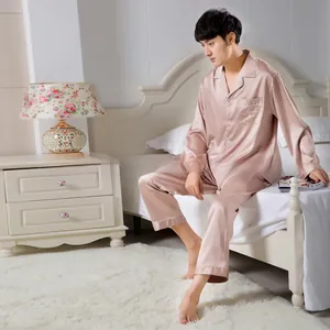 Close-up of men's pink satin silk pajama set with elegant embroidery in bedroom scene