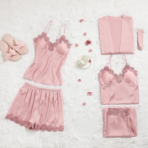 Ensemble de détente en satin rose avec bordure en dentelle sur un tapis blanc moelleux