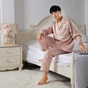 Close-up of champagne satin men's pajamas with white piping and embroidery details