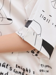 Dettaglio camicia da notte bianca in seta di ghiaccio con risvolto manica e stampa