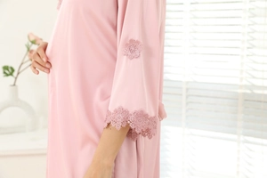 Gros plan du peignoir en satin rose avec broderie de dentelle élégante sur les manches