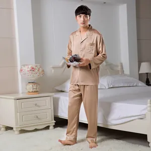 Detailed view of champagne gold satin pajamas with white piping and chest embroidery