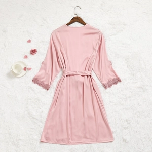 Vue détaillée du peignoir en satin rose pâle avec poignets en dentelle et ceinture