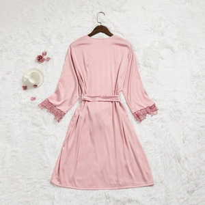 Vue détaillée d'un peignoir en satin rose avec bordure en dentelle florale et tissu soyeux