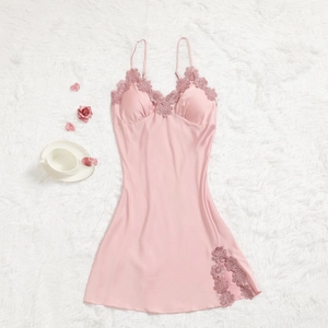 Détail d'une chemise de nuit en satin rose avec dentelle élégante et fente sur tapis doux