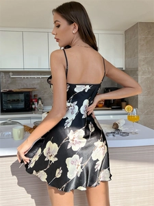Détail d'une nuisette en satin à fleurs montrant les fines bretelles et le dos soyeux