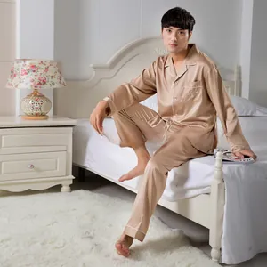Detail of champagne gold satin men's pajamas with white contrast piping and embroidery