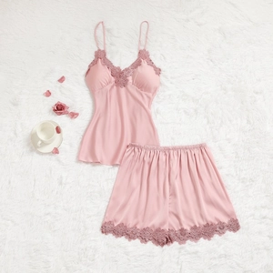 Détail de l'ensemble pyjama en satin de soie rose avec bordure en dentelle florale