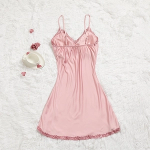 Détail d'une nuisette en satin rose avec bordure en dentelle sur tapis en peluche