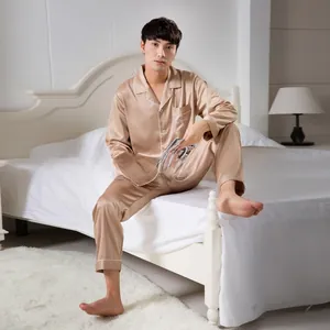 Detail of champagne satin pajama set featuring chest pocket and white letter embroidery