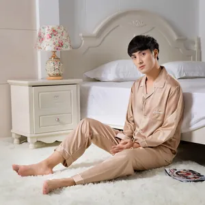 Detail of champagne gold satin pajamas set featuring classic lapel with white piping trim