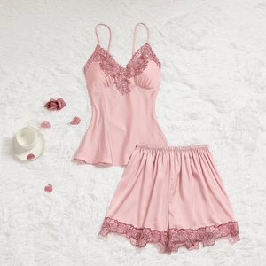 Ensemble de pyjama en satin rose avec bordure en dentelle sur fond de fausse fourrure