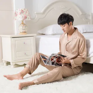 Detail of premium champagne satin men's pajama set featuring white piping and chest pocket