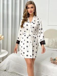 Détail d'un peignoir en satin de soie fleuri avec dentelle noire et ceinture ajustable