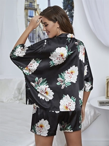 Detailed view of women's black floral satin pajamas with elegant kimono sleeves and drape