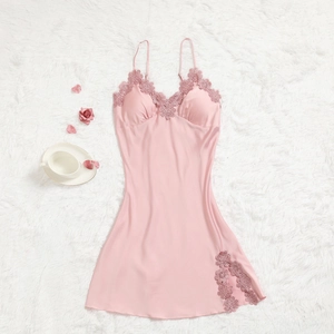 Nuisette en satin de soie rose avec dentelle et fines bretelles sur tapis en fourrure