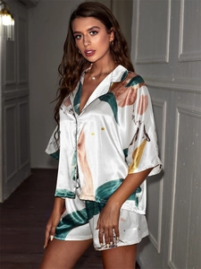 Detail of satin ice silk pajamas with abstract green and orange ink print textures