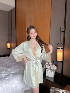 Detail of mint green silk robe showing delicate beige lace trim and satin waist tie