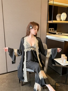Detail of black silk pajama set with delicate yellow lace trim and elegant bow accent