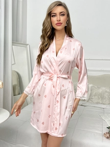 Vue détaillée d'un peignoir en satin rose avec motifs de cœurs et dentelle aux poignets