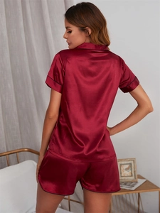 Vue détaillée du pyjama en soie bordeaux avec liseré noir et texture satinée et lisse