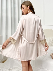 Detail view of pink satin robe showing elegant lace patchwork on long sleeves