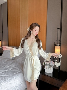 Close-up of elegant cream satin pajama robe with intricate light gold lace trim details