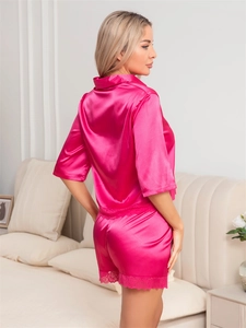 Close-up of rose red satin pajamas featuring elegant lace trim on shorts and hem