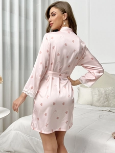 Vue détaillée du peignoir rose en soie avec poignets en dentelle et motifs de cœurs
