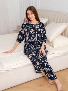 Detail view of navy blue floral pajamas set with buttoned top and long pants in bedroom